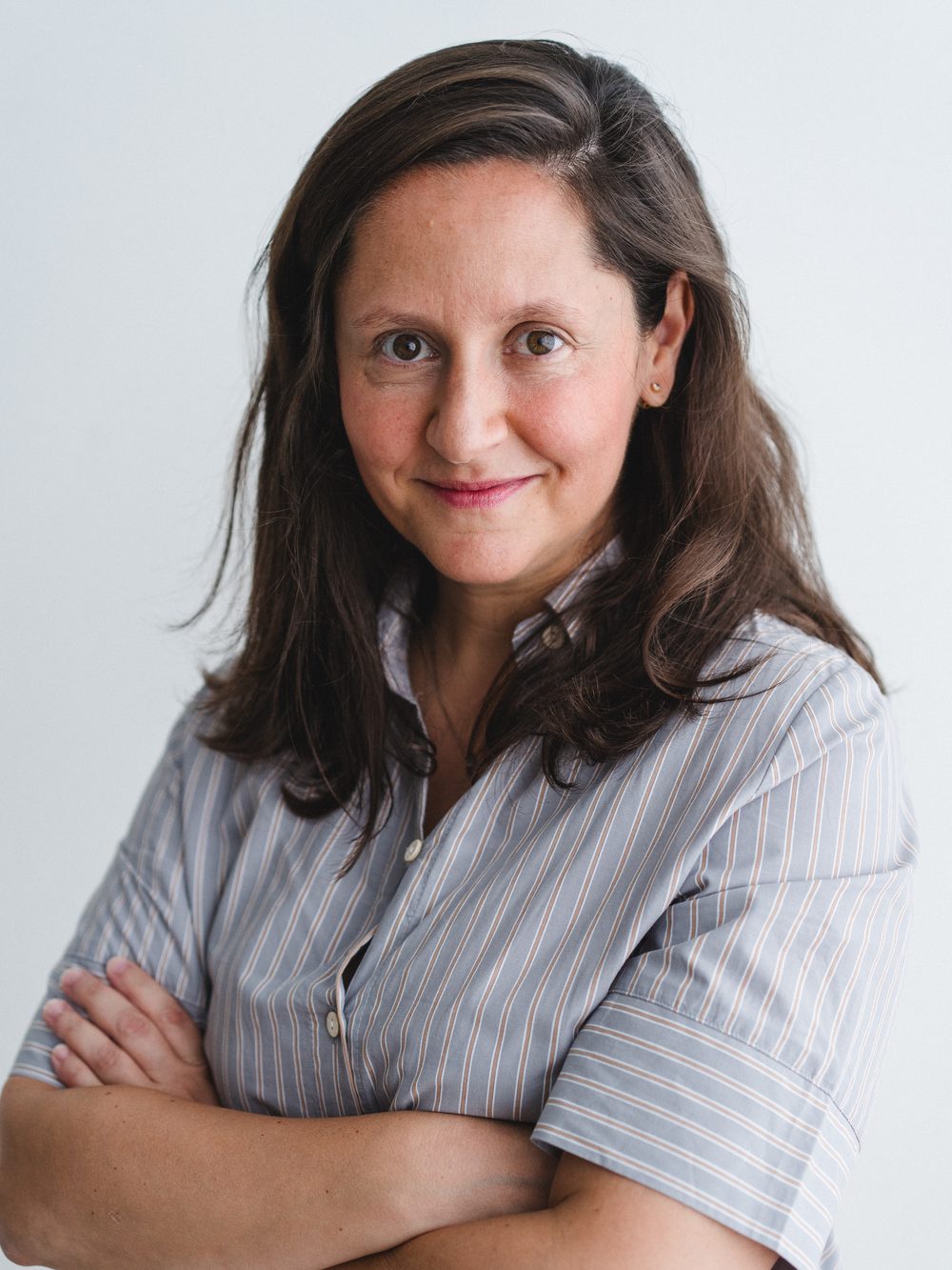 La Dra. Lara Quintas Marquès, ginecóloga especialista en dolor pélvico crónico y endometriosis en Barcelona, de pie y con los brazos cruzados